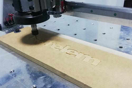 CNC Router graviert den Schriftzug "norelem" in ein Holzbrett