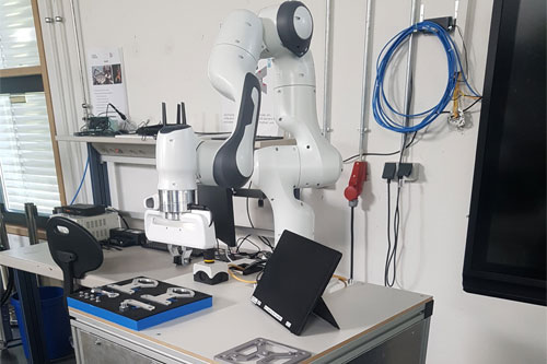 auf einem Tisch steht ein Roboterarm und Werkzeug